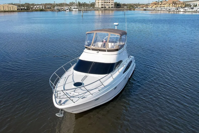 Slide: The Image of 2003 Regal Commodore 3880 yacht on calm water, showcasing sleek design and spacious deck. - 4