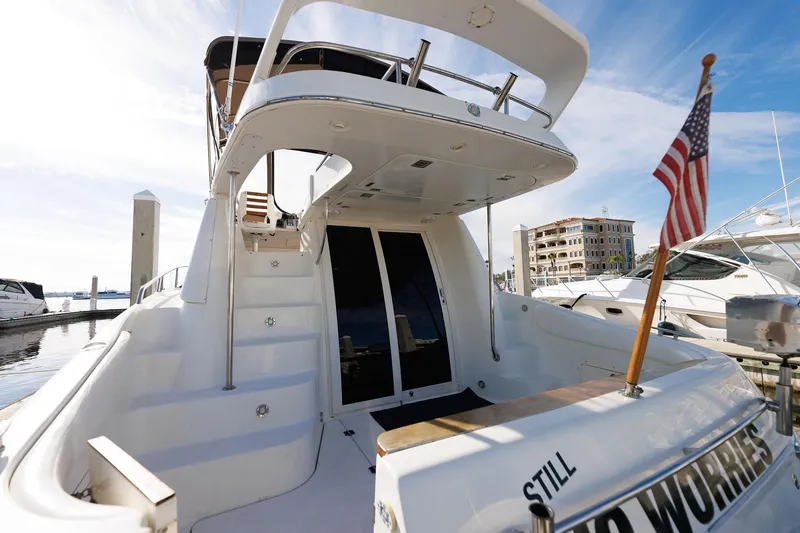 Slide: The Image of 2003 Regal Commodore 3880 yacht docked, featuring spacious deck and American flag. - 40