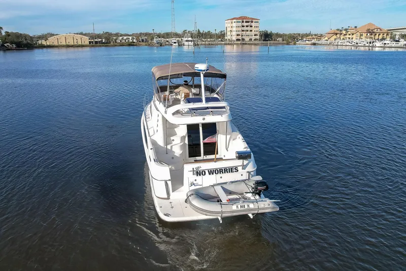 Slide: The Image of 2003 Regal Commodore 3880 yacht cruising on a calm lake with scenic background. - 9