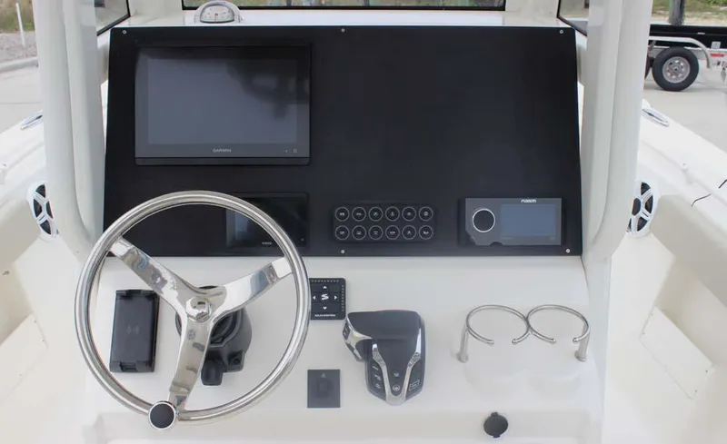 Slide: The Image of 2025 Key West 239 FSR boat dashboard with steering wheel, navigation screens, and controls. - 9