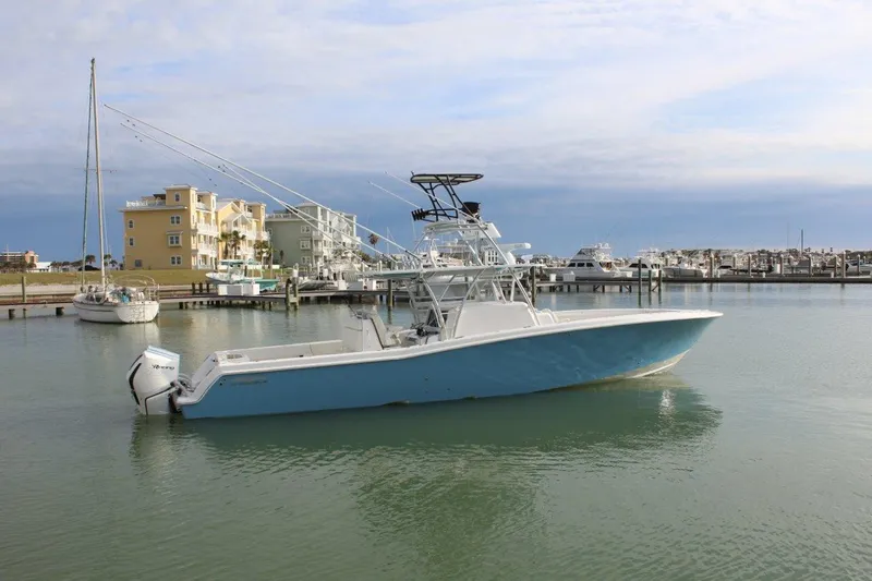 Slide: The Image of 2020 Invincible Center Cabin boat docked in a marina with coastal buildings. - 0