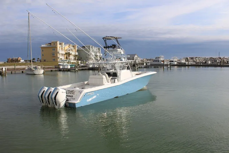 Slide: The Image of 2020 Invincible Center Cabin boat docked in a marina with multiple engines. - 1