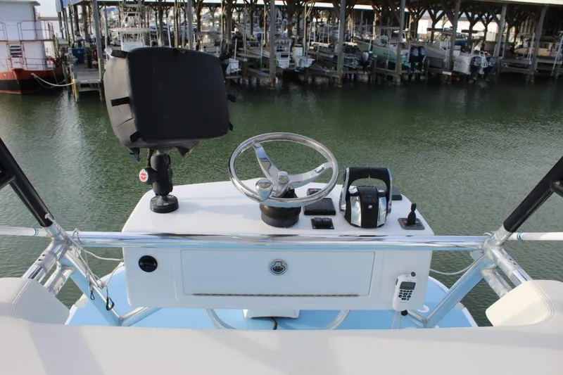 Slide: The Image of 2020 Invincible Center Cabin boat helm with steering wheel and controls at marina. - 10