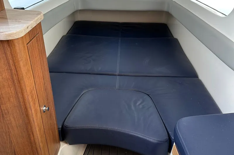 Slide: The Image of 2020 Invincible Center Cabin interior with blue cushioned seating and wooden cabinetry. - 11