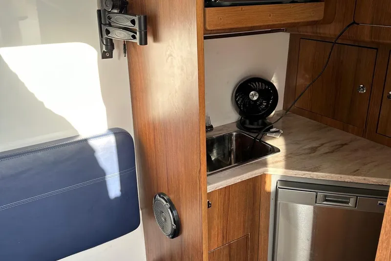 Slide: The Image of 2020 Invincible Center Cabin interior with kitchenette, sink, and wooden cabinetry. - 12