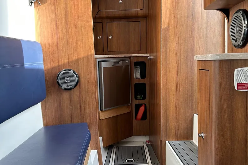 Slide: The Image of 2020 Invincible Center Cabin interior with wood finish, seating, and storage compartments. - 13