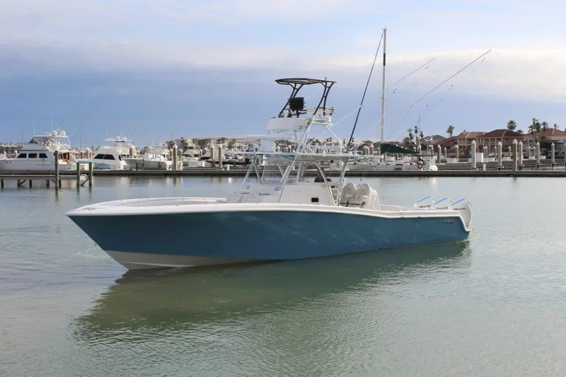 Slide: The Image of 2020 Invincible Center Cabin boat docked in a marina, calm waters, overcast sky. - 2