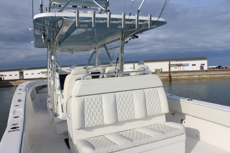 Slide: The Image of 2020 Invincible Center Cabin boat with white seating, docked by the water. - 4