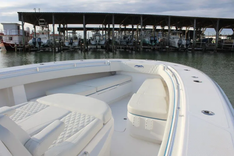 Slide: The Image of 2020 Invincible Center Cabin boat docked, featuring spacious seating and elegant design. - 8