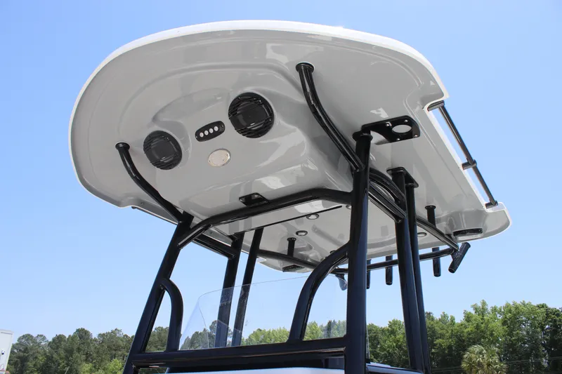 Slide: The Image of 2025 Sea Pro 230 Bay boat T-top with speakers and lights, under clear blue sky. - 13
