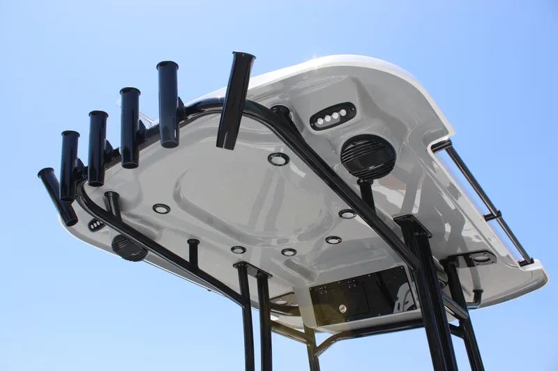 Slide: The Image of 2025 Sea Pro 230 Bay boat T-top with rod holders and LED lights against blue sky. - 14