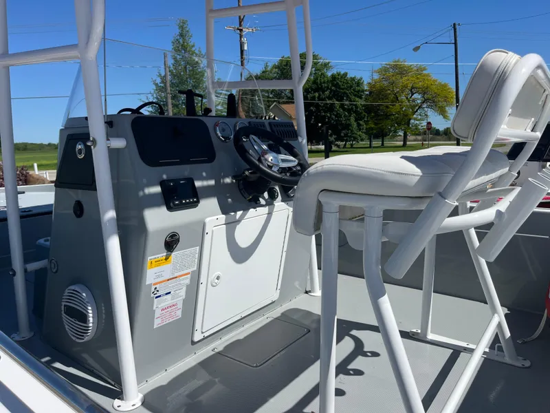 Slide: The Image of 2023 Charger 2230 L Sport boat console with steering wheel and seating, outdoors. - 9