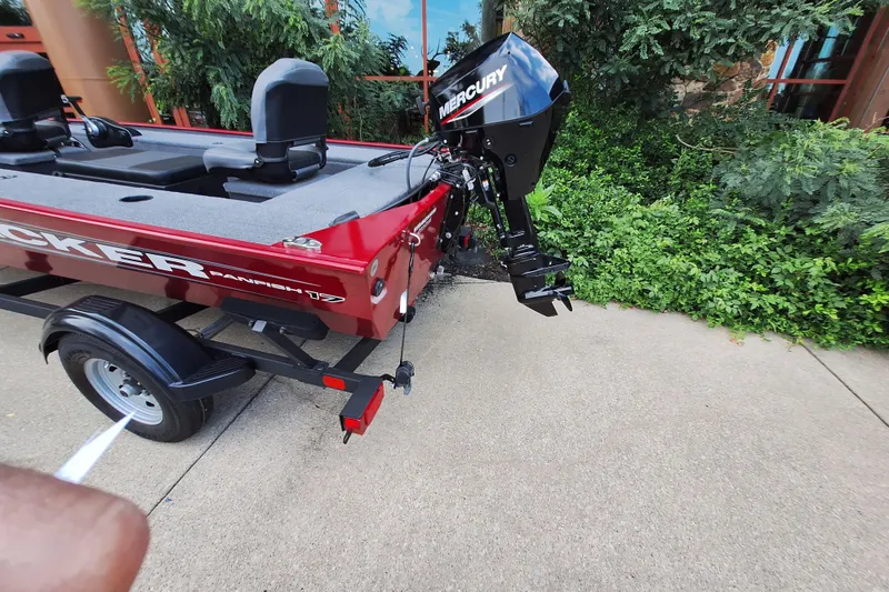 Slide: The Image of 2025 Tracker Panfish 17 boat with Mercury outboard motor, parked on a concrete surface. - 2