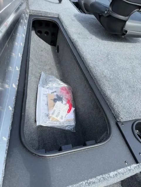 Slide: The Image of Storage compartment in 2025 Tracker Pro Team 175 boat, with accessories and carpeted interior. - 4