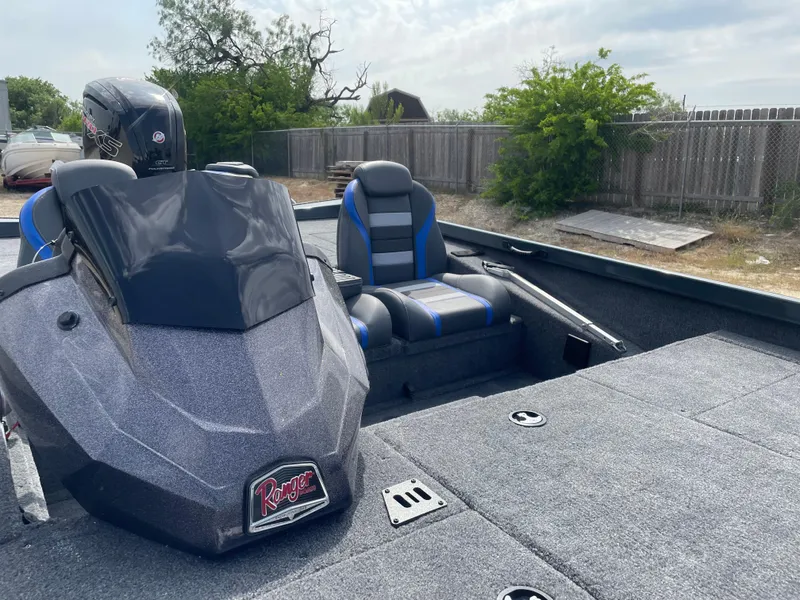Slide: The Image of 2025 Ranger RT188P boat interior with seating and console, outdoors near a wooden fence. - 6
