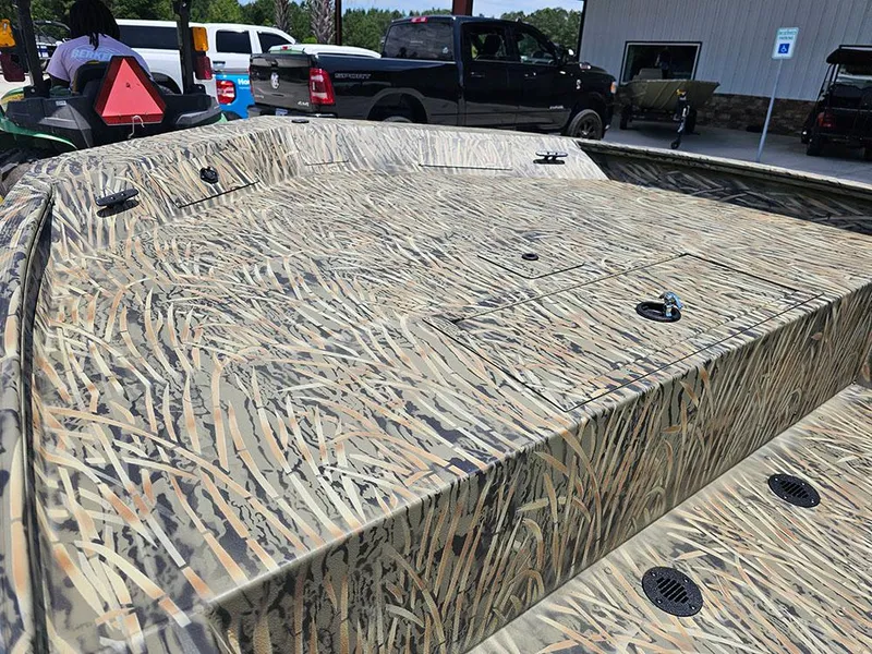 Slide: The Image of 2025 Tracker Grizzly 1860 CC boat with camouflage pattern in outdoor setting. - 13