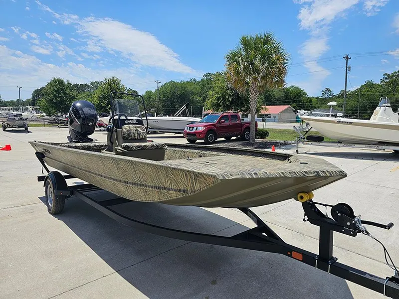 Slide: The Image of 2025 Tracker Grizzly 1860 CC boat on trailer, parked outdoors under blue sky. - 5