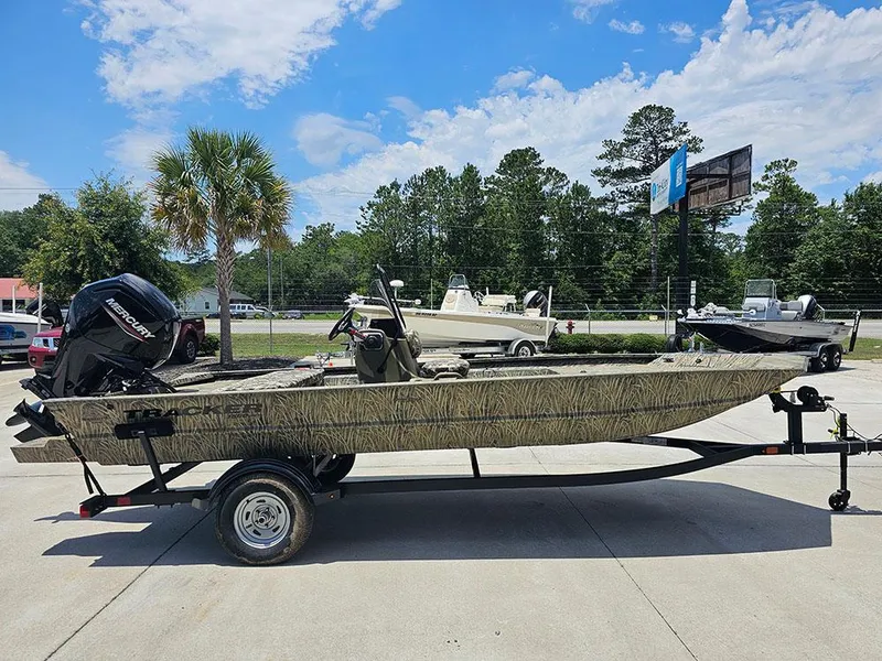 Slide: The Image of 2025 Tracker Grizzly 1860 CC boat on trailer, parked outdoors under a clear sky. - 6