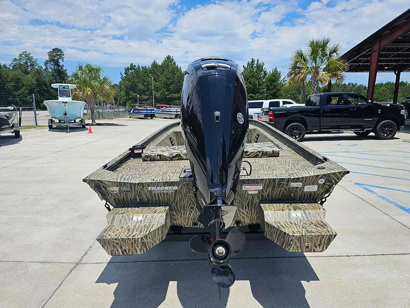 Slide: The Image of 2025 Tracker Grizzly 1860 CC boat with camouflage design, parked outdoors. - 8
