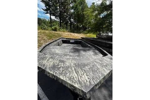 Slide: The Image of 2025 Tracker Grizzly 1860 Utility boat with camouflage design in outdoor setting. - 2
