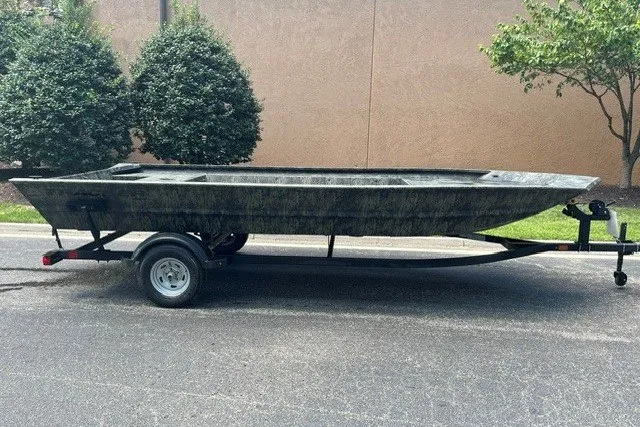 The Image of 2025 Tracker Grizzly 1860 Utility boat on trailer, parked outdoors. - 0