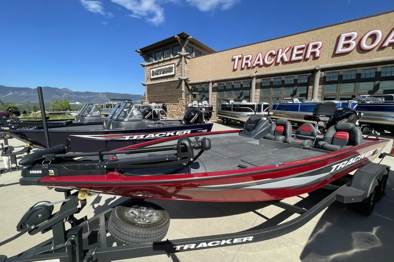Slide: The Image of 2025 Tracker Savage 215 boat displayed at Tracker Boats dealership. - 2