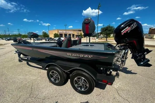 Slide: The Image of 2025 Ranger RT188P boat with trailer, parked outdoors under a clear blue sky. - 2