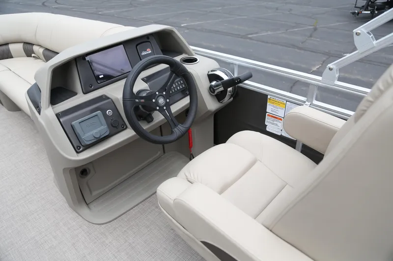 Slide: The Image of 2025 Sun Tracker Party Barge 20 DLX helm with steering wheel and beige seating. - 3