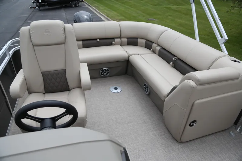 Slide: The Image of 2025 Sun Tracker Party Barge 20 DLX interior with beige seating and steering wheel. - 4