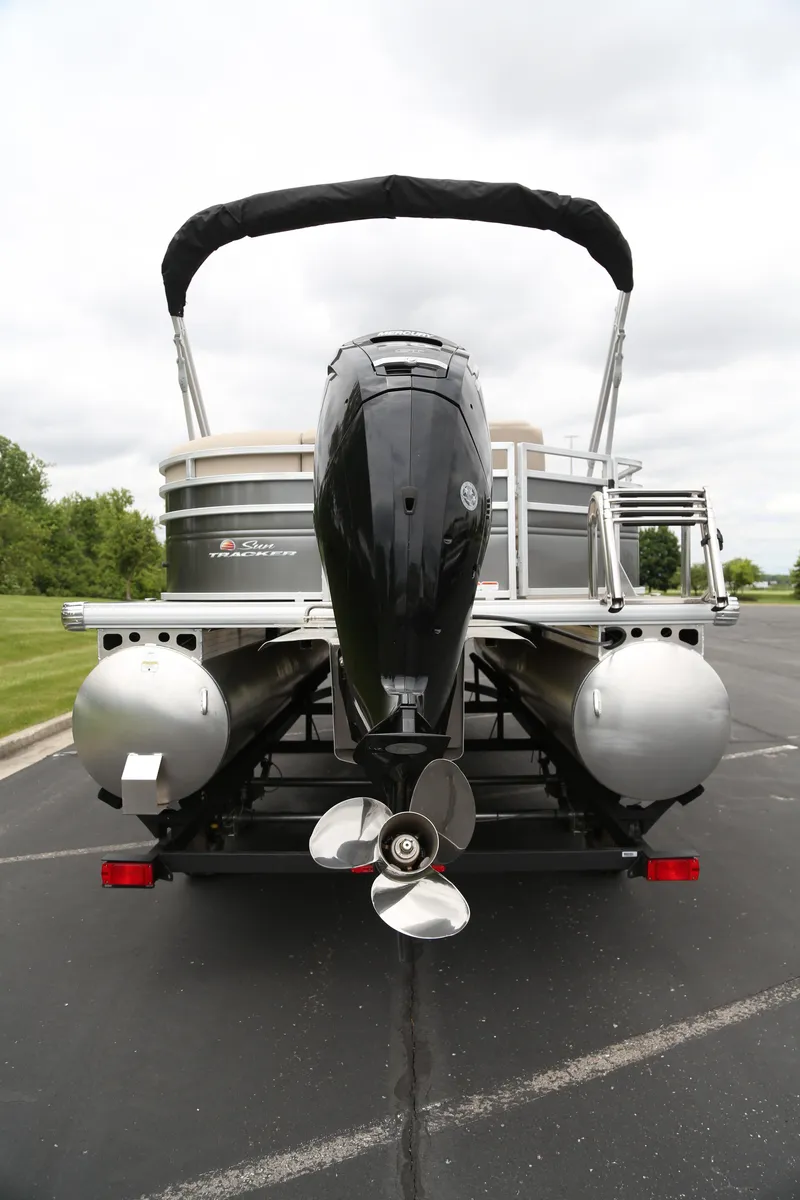 Slide: The Image of 2025 Sun Tracker Party Barge 20 DLX pontoon boat, rear view with motor and pontoons. - 6