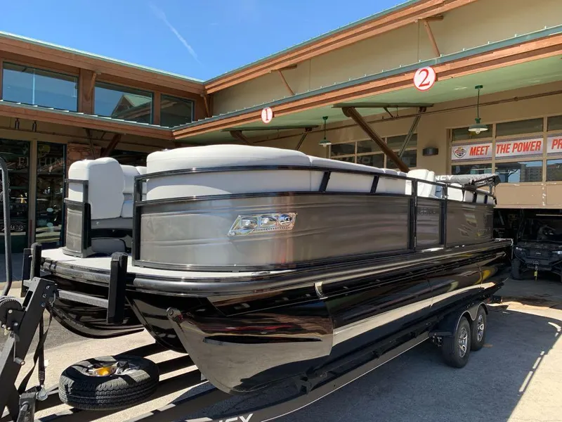 Slide: The Image of 2025 Regency 230 LE3 pontoon boat on trailer, displayed outdoors. - 2