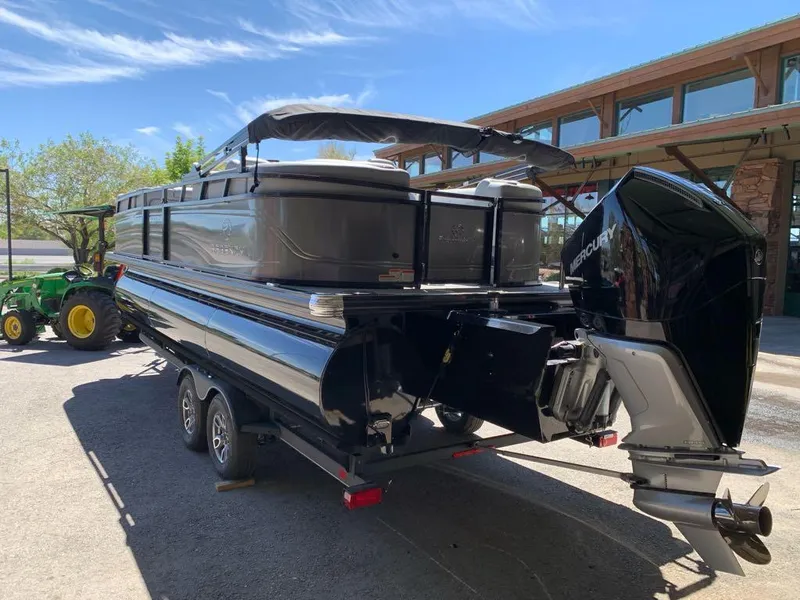 Slide: The Image of 2025 Regency 230 LE3 pontoon boat with Mercury outboard engine on a trailer. - 6
