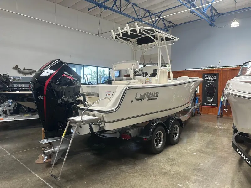 Slide: The Image of 2025 Mako 214 CC boat with Mercury engine displayed indoors on a trailer. - 5