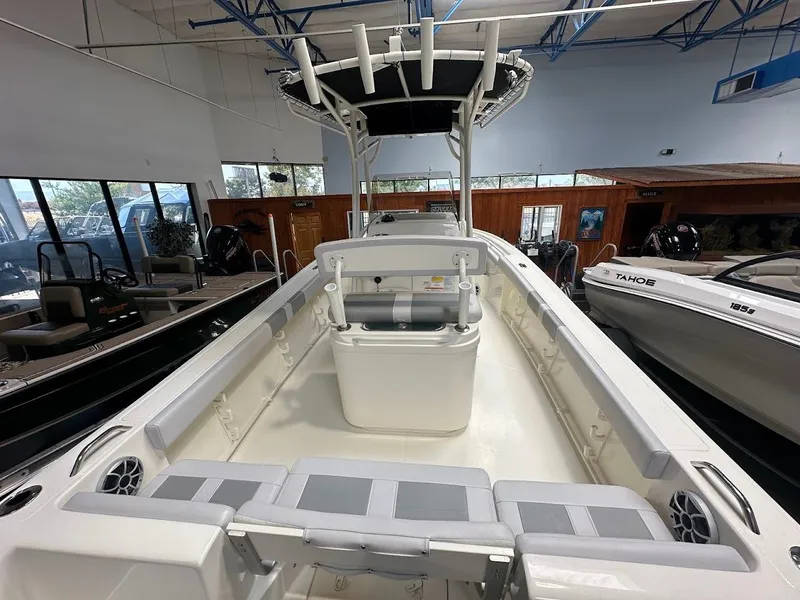 Slide: The Image of 2025 Mako 214 CC boat interior with seating and storage, displayed in a showroom. - 7