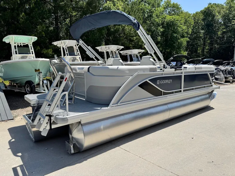 Slide: The Image of 2025 Godfrey Sweetwater 2086 SB pontoon boat with canopy, parked outdoors. - 3