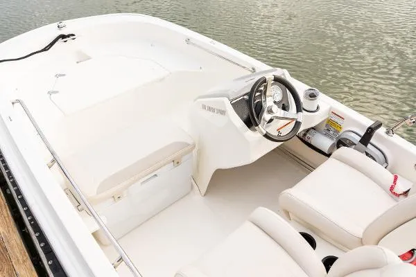 Slide: The Image of 2025 Boston Whaler 130 SUPERSPORT boat interior with steering console and seating. - 1
