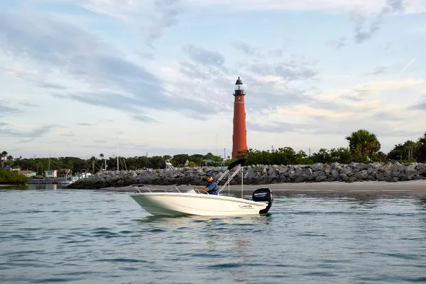 Slide: The Image of 2025 Boston Whaler 130 SUPERSPORT boat near a lighthouse on calm waters. - 4