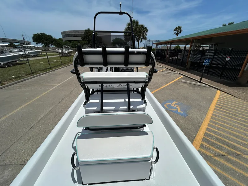 Slide: The Image of 2025 Shallow Stalker CAT 211 PRO boat, docked, with seating and console, under clear skies. - 10