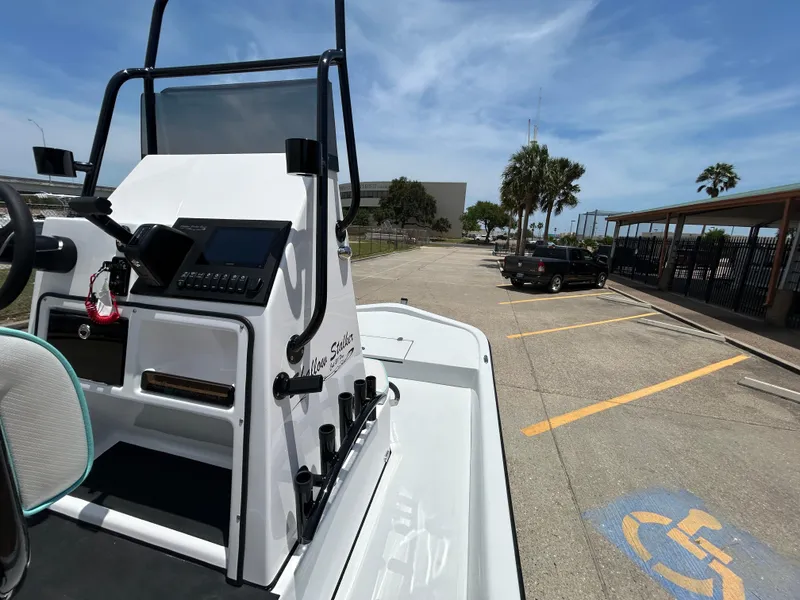 Slide: The Image of 2025 Shallow Stalker CAT 211 PRO boat parked in sunny lot near palm trees. - 12