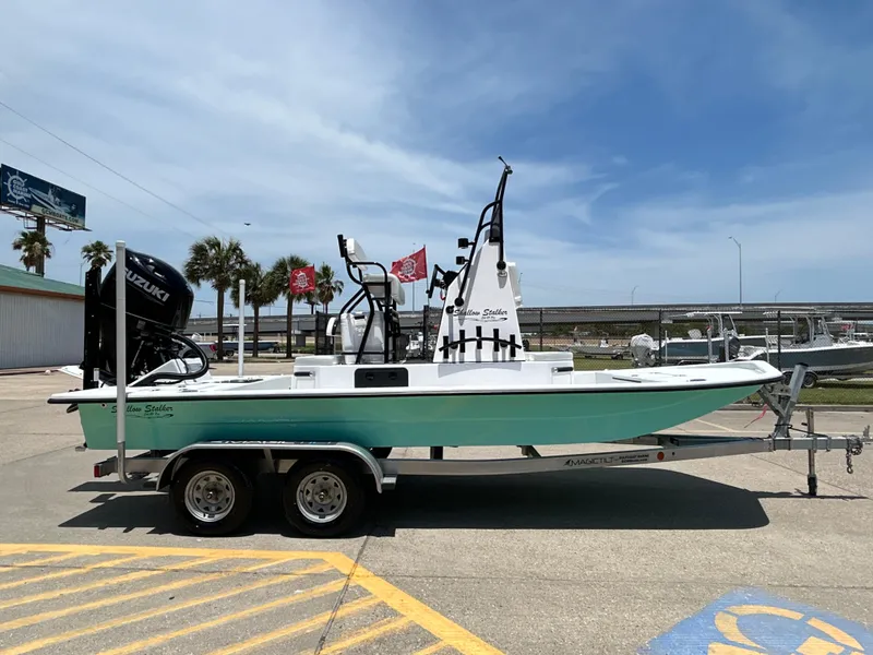Slide: The Image of 2025 Shallow Stalker CAT 211 PRO boat on trailer, parked outdoors under clear sky. - 5