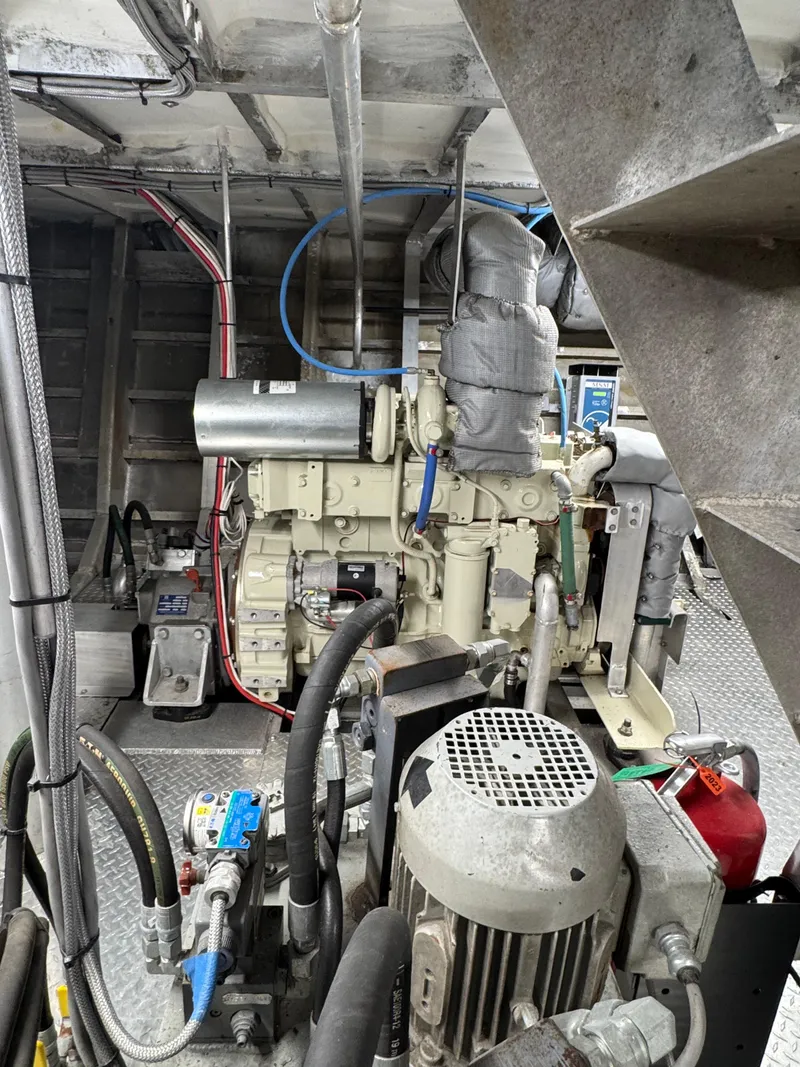 Slide: The Image of Engine room of a 1985 custom house boat with visible machinery and wiring. - 10
