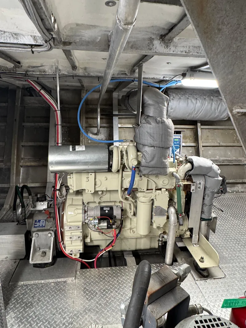 Slide: The Image of Engine room of a 1985 custom houseboat, featuring complex machinery and wiring. - 11