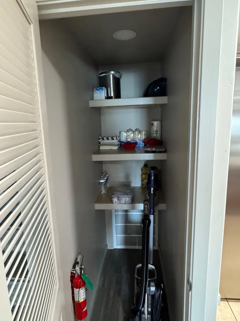 Slide: The Image of Small storage closet with shelves, vacuum, and fire extinguisher on a 1985 custom houseboat. - 21