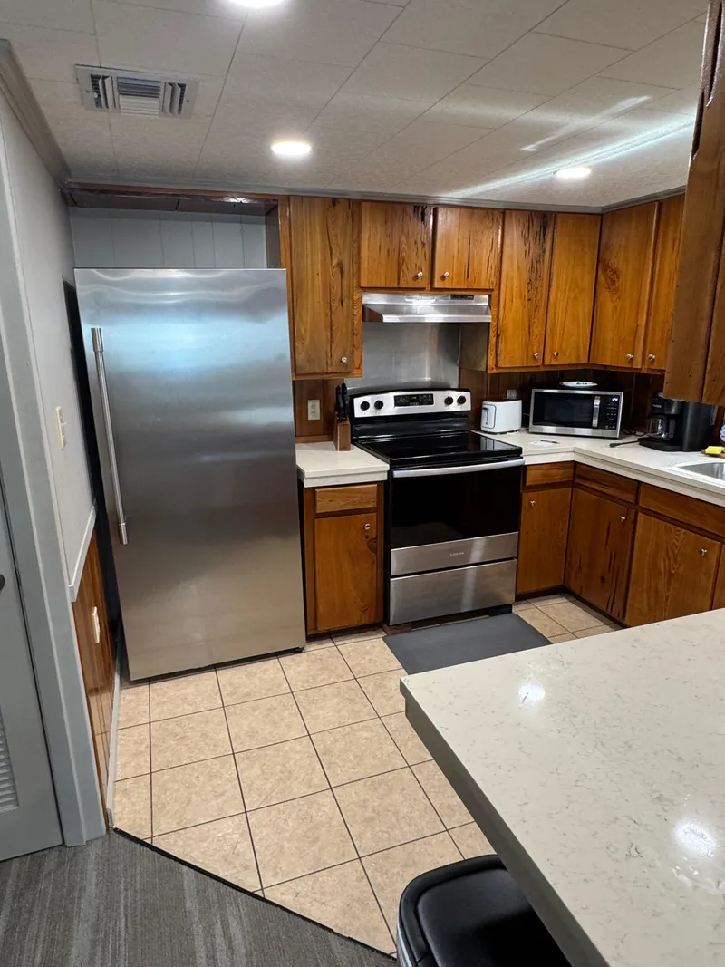 Slide: The Image of Modern kitchen in a 1985 custom houseboat with stainless steel appliances and wooden cabinetry. - 22