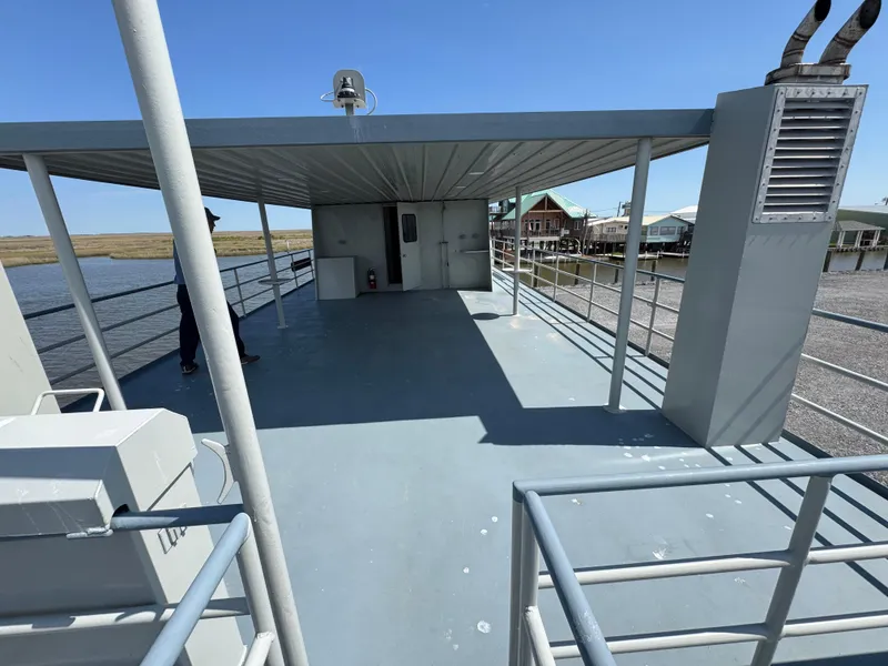 Slide: The Image of Custom 1985 houseboat deck with railing, covered area, and scenic waterfront view. - 24