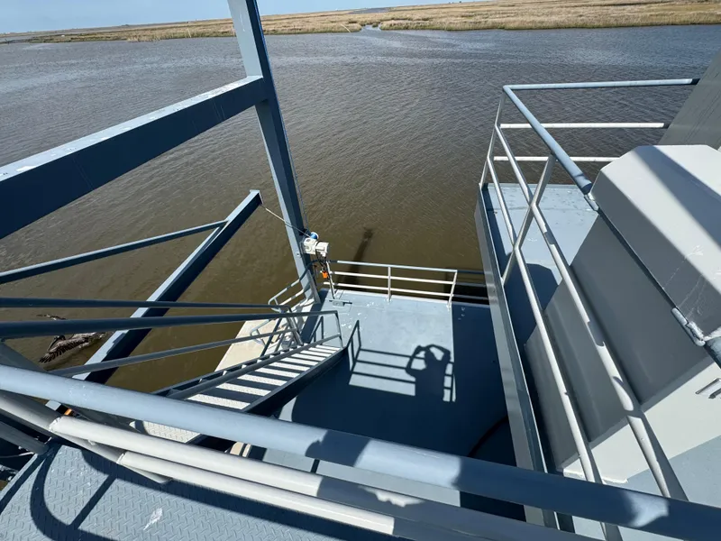 Slide: The Image of Staircase on a 1985 custom houseboat overlooking calm waters and marshland. - 26