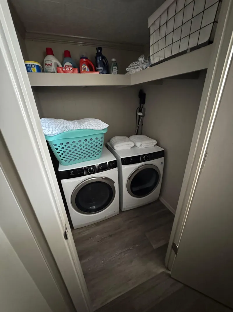Slide: The Image of Laundry room on 1985 custom houseboat with washer, dryer, and shelves for supplies. - 28