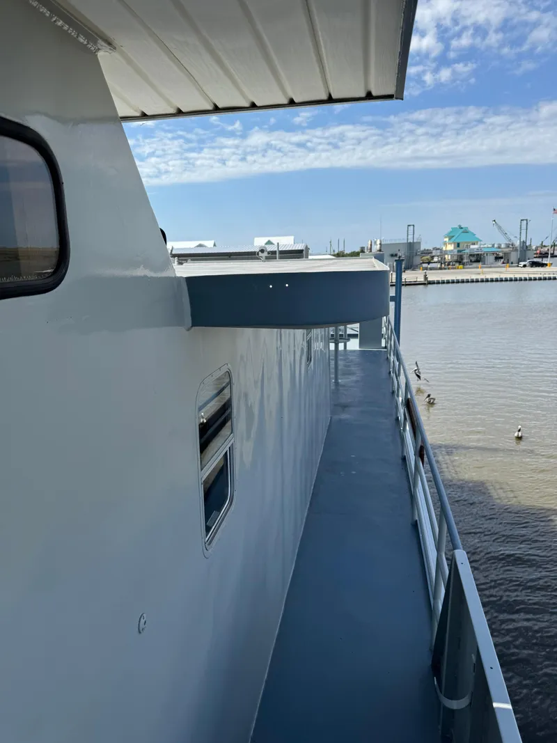 Slide: The Image of 1985 Custom House Boat docked by a calm waterfront under a clear blue sky. - 35