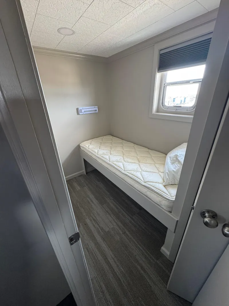 Slide: The Image of Small bedroom on a 1985 custom houseboat with single bed and window. - 36