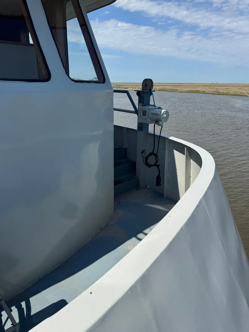 Slide: The Image of 1985 custom house boat on calm water under a clear blue sky. - 40